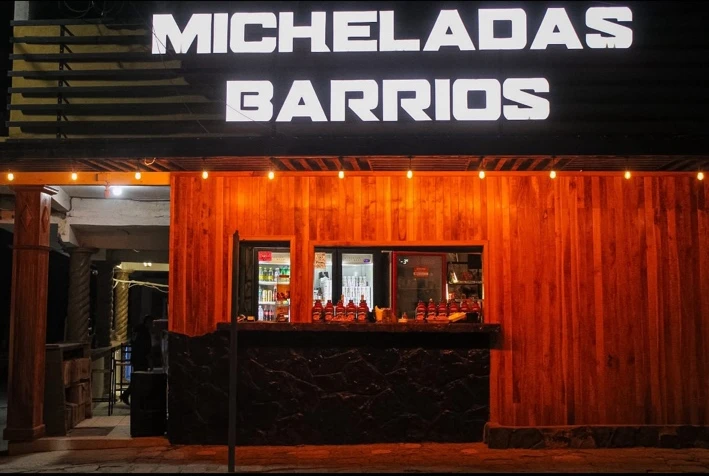 Fachada real de Micheladas Barrios con iluminación cálida